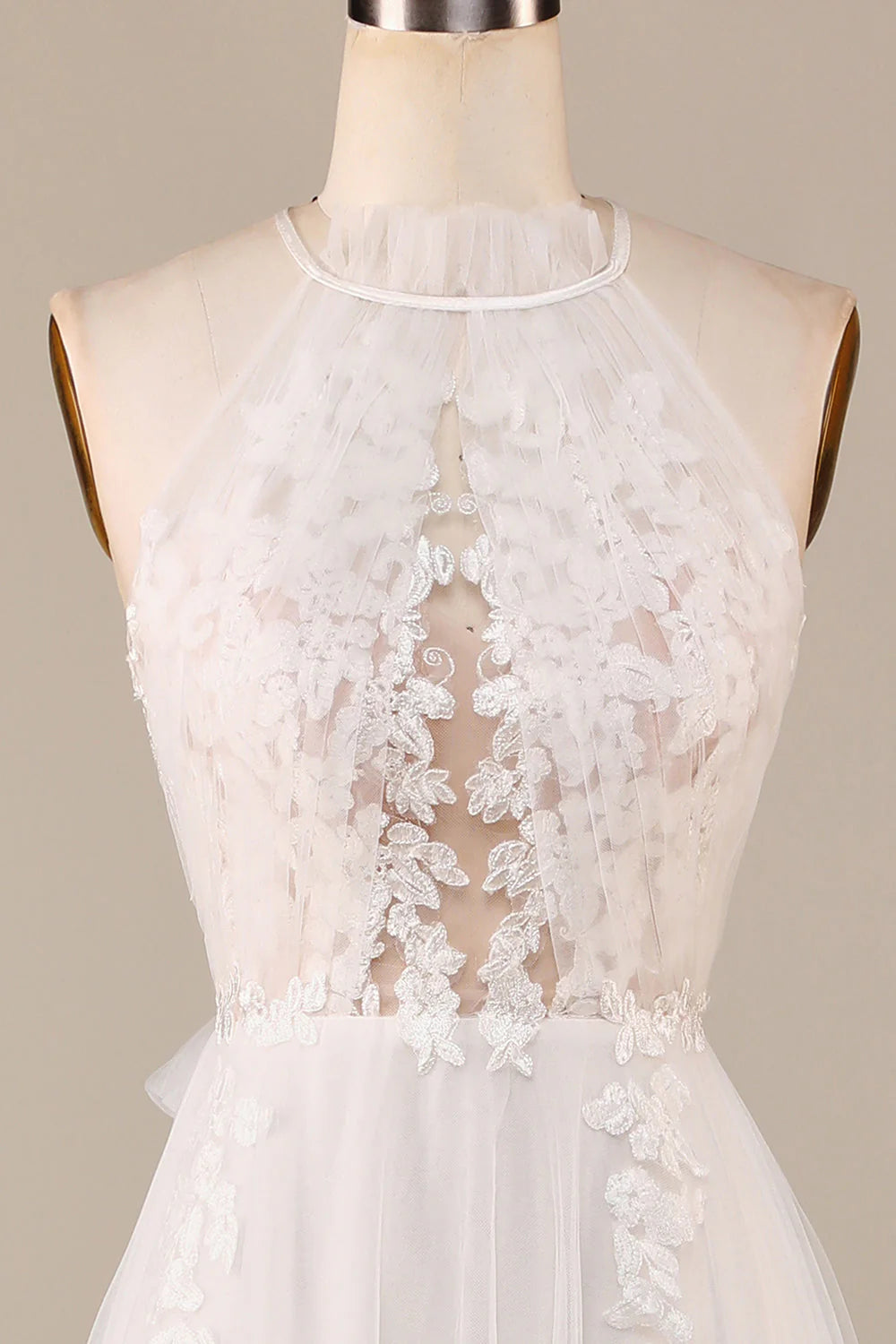 Un grazioso abito da sposa in pizzo trasparente color avorio, senza maniche, con scollatura a trapezio e schiena scoperta.